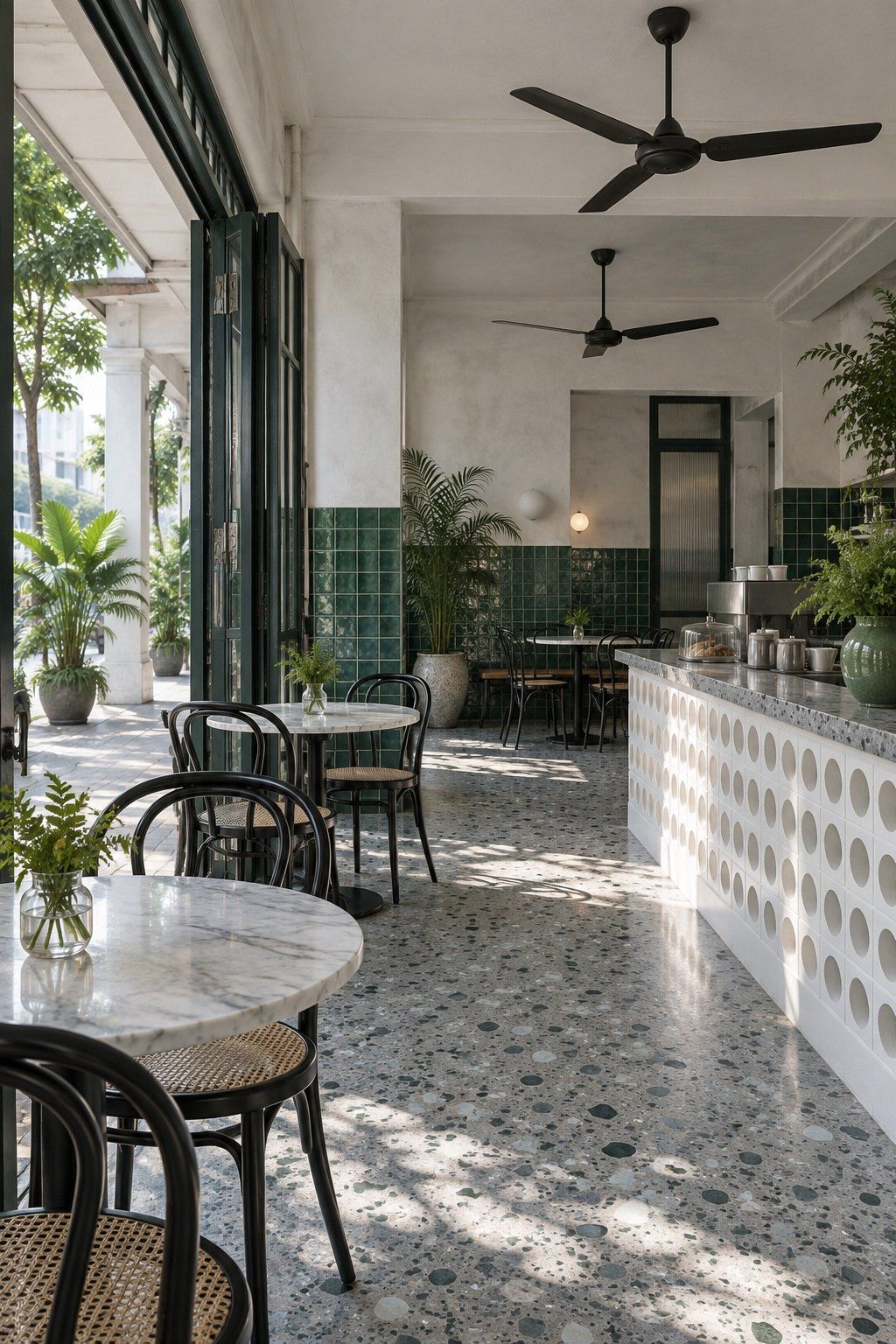 Small café interior with green glazed wall tiles, a breeze-block counter front and ceiling fans