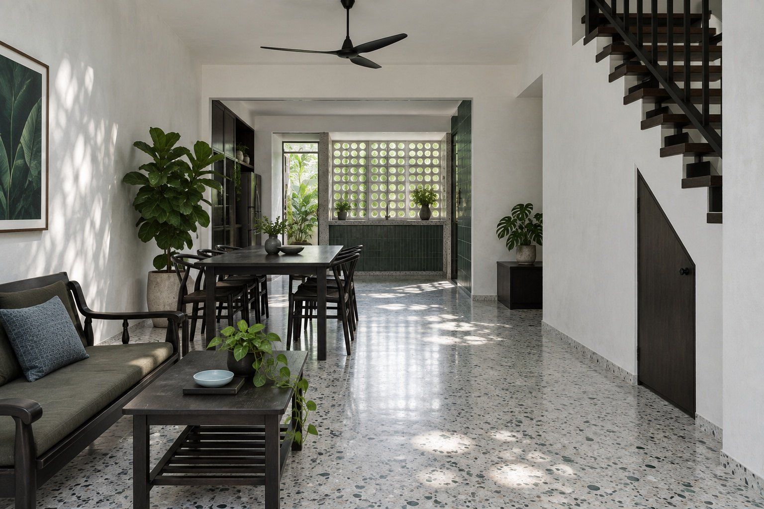 Renovated terrace house living room with a breeze-block wall, grey terrazzo floor and dark timber stair